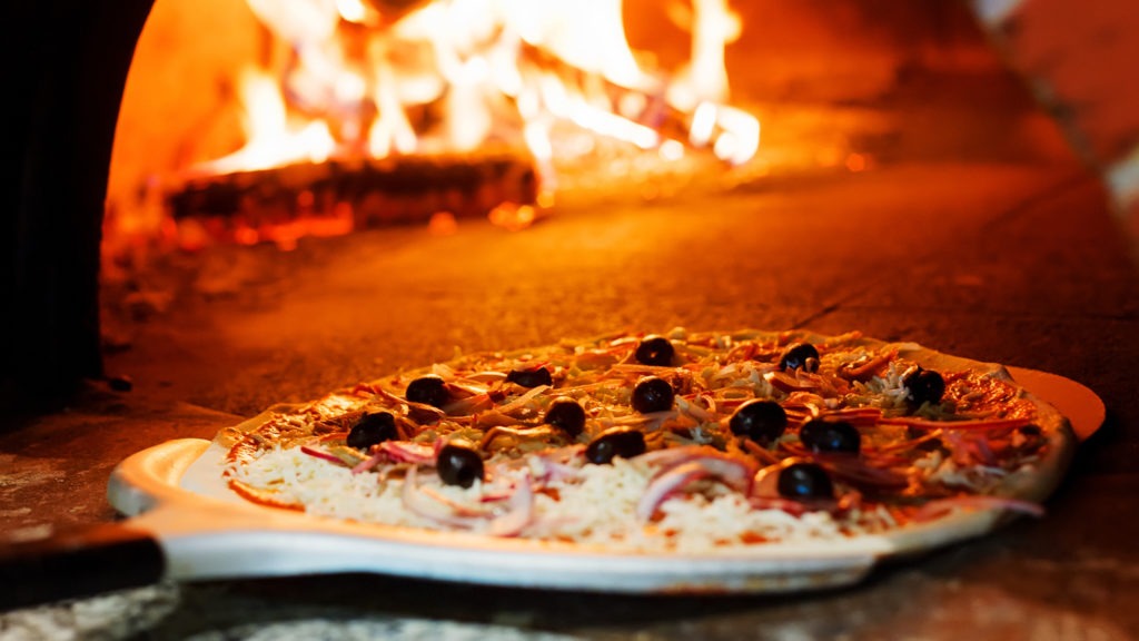 A raw pizza to be placed in a hot oven