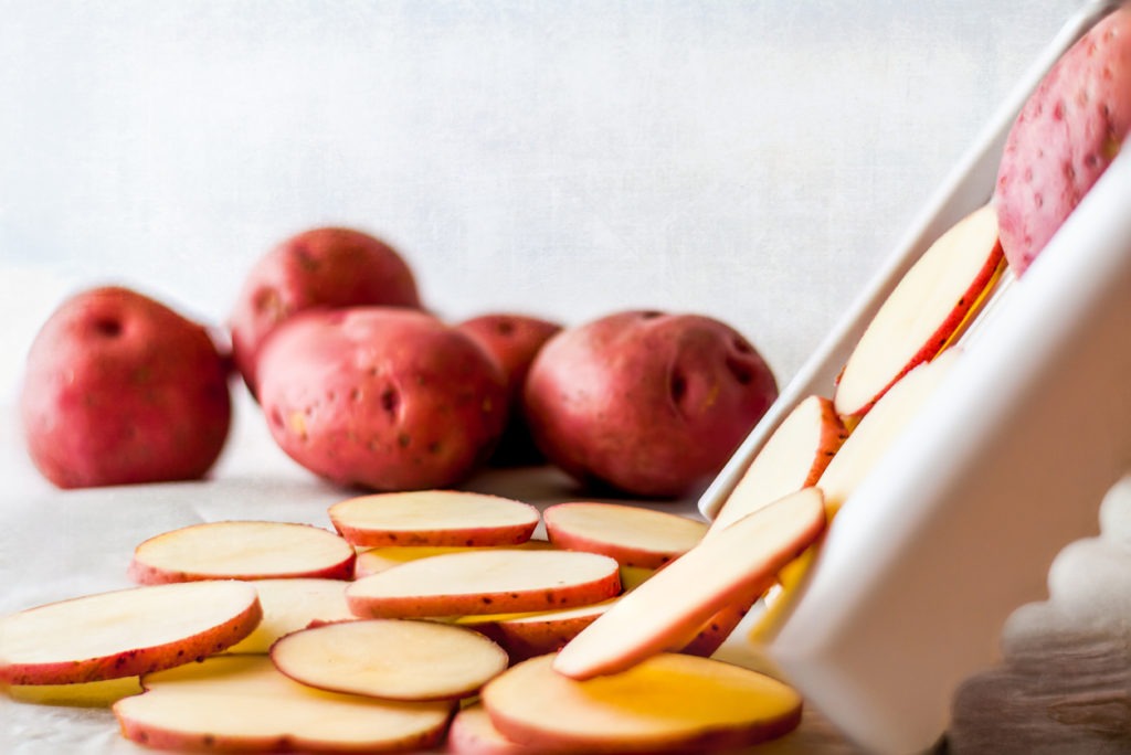 Close-up of red potatoes and a slicer