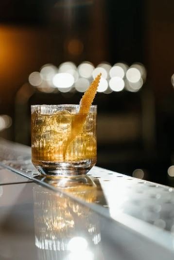 an alcohol drink in a mug with a peeled citrus zest