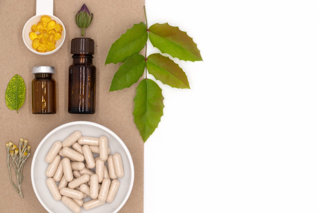 pills, capsules, supplements, oils and herbs in blank space