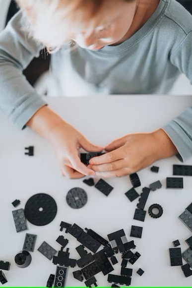 a kid building something using Lego