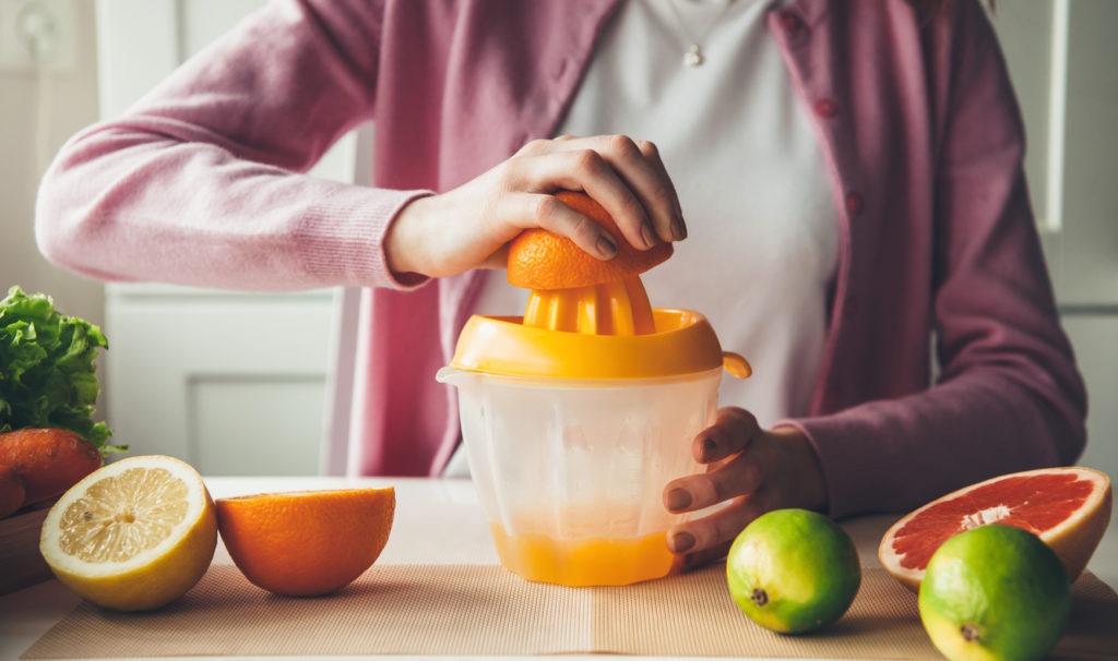 woman using a manual fruit juicer