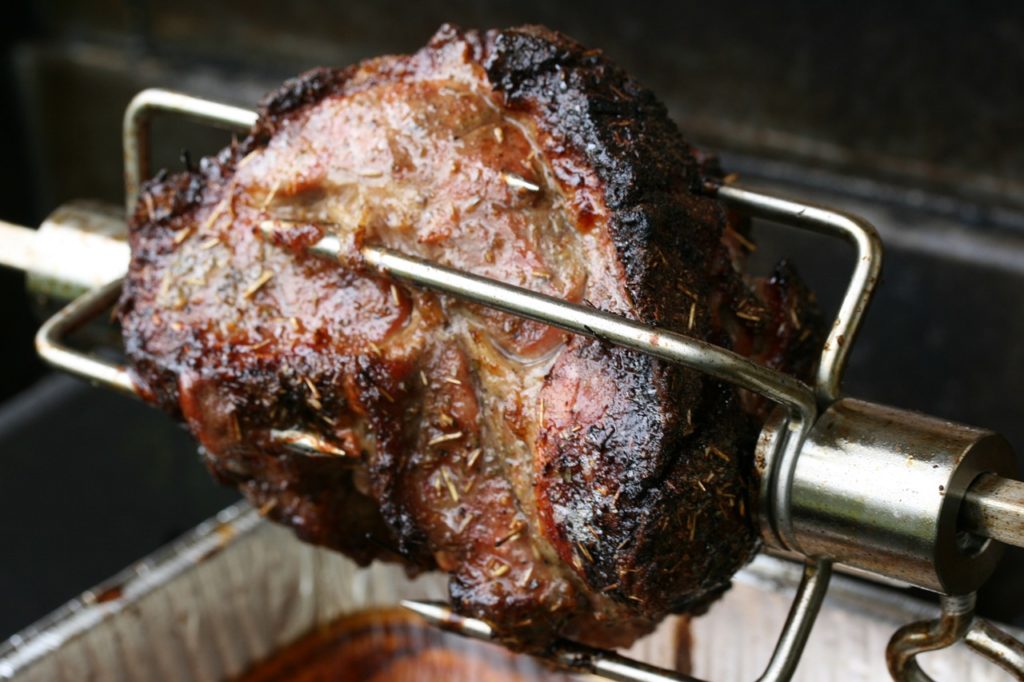 cooking meat on a rotisserie grill