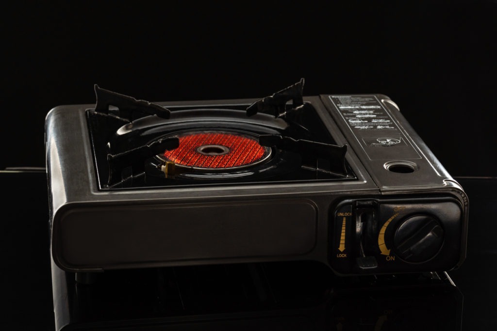 Camping portable gas ceramic hob, works and stands on a black