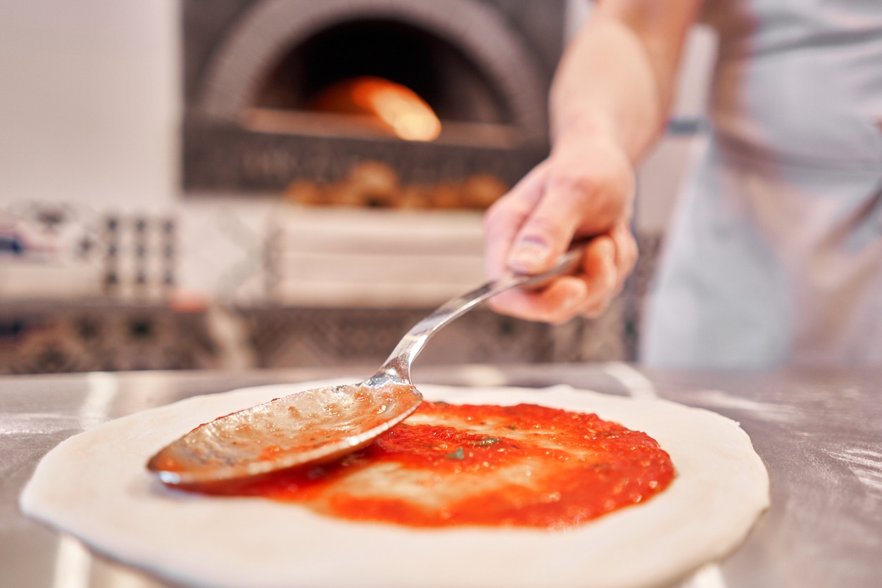 pizza master adding hot sauce on the pizza