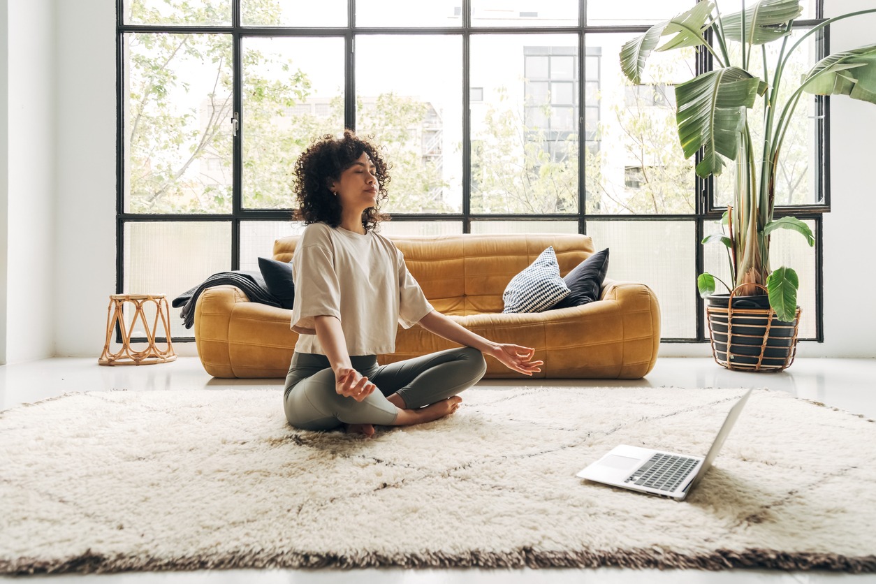 Meditating, Yoga, Mental Health, Wellbeing, Relaxation, Relaxation Exercise, Mindfulness, Lifestyles, Emotional Stress, Healthy Lifestyle, Internet, Living Room, Indoors, Young Women, Mental Wellbeing, Practicing, Yoga Class, Spirituality, Flooring, Learning, Sitting, Cross-Legged, Zen-like