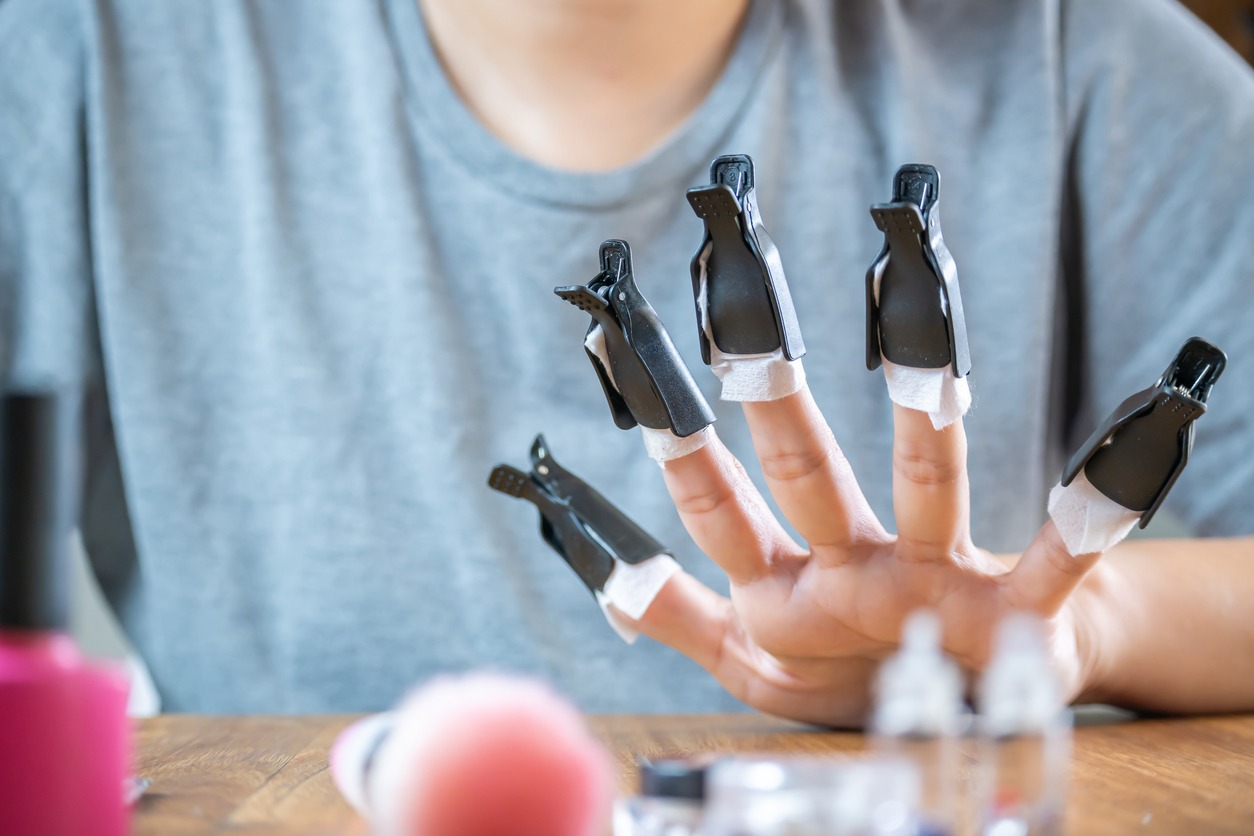 Woman's hands with presses to remove semi-permanent nail polish