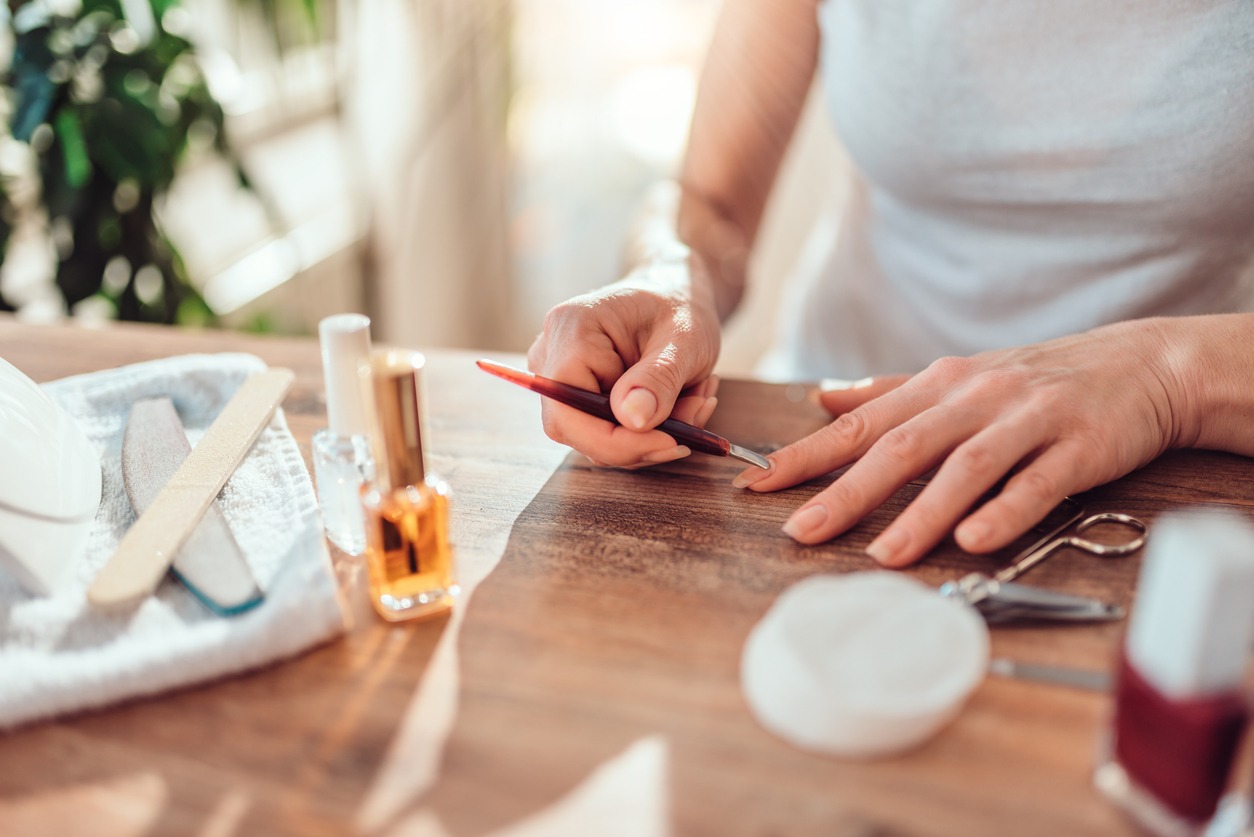 Woman using cuticle pusher