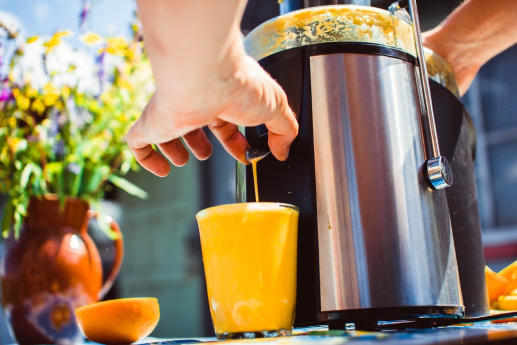 A man preparing juice using a juice extractor