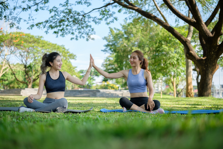 Female friends doing yoga and mindfulness in a park