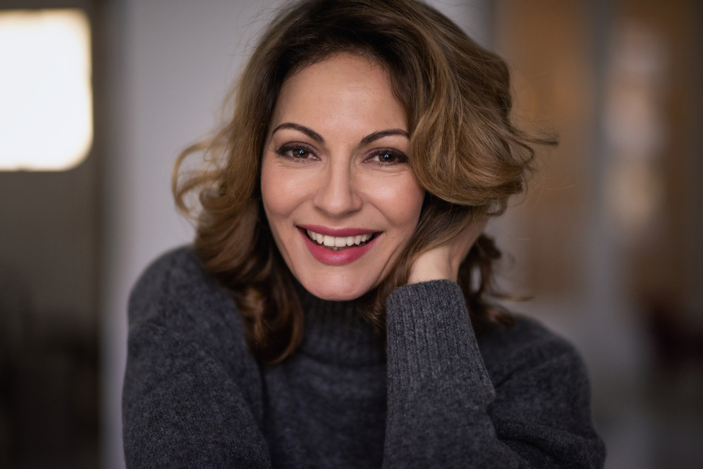 Blond haired woman portrait sitting against indoor