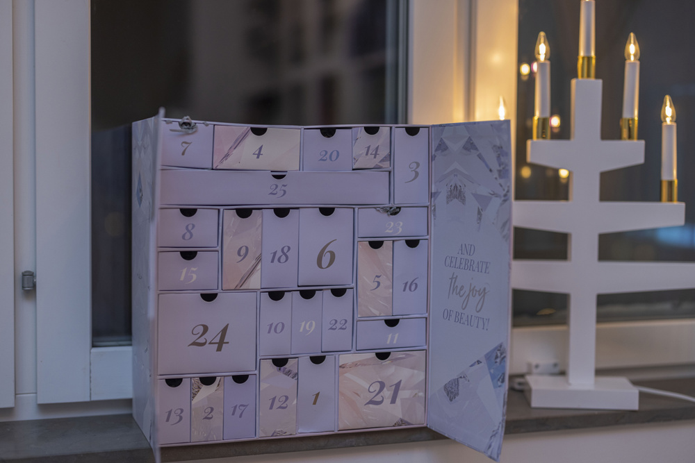 View of advent calendar and traditional electric Christmas candlestick on window. Sweden