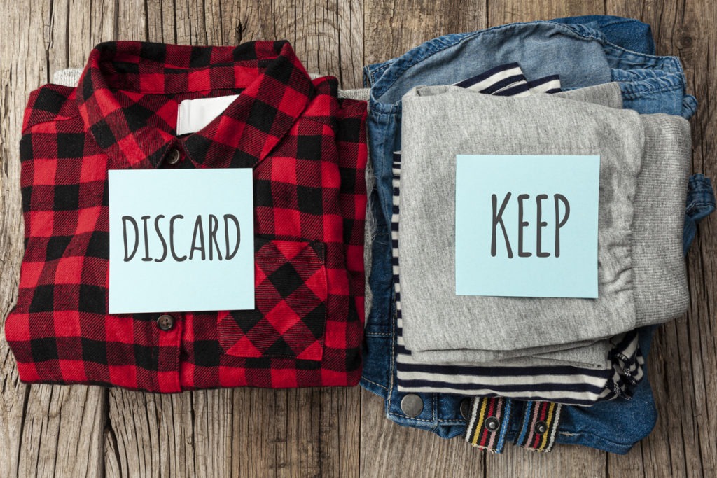 Stack of old clothes to discard (declutter) or keep. Recycle clothes, eco cotton
