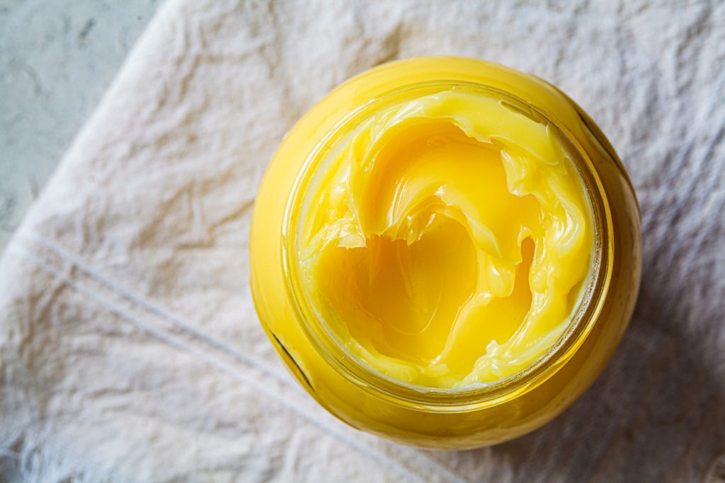 Glass jar holding ghee butter, top view.