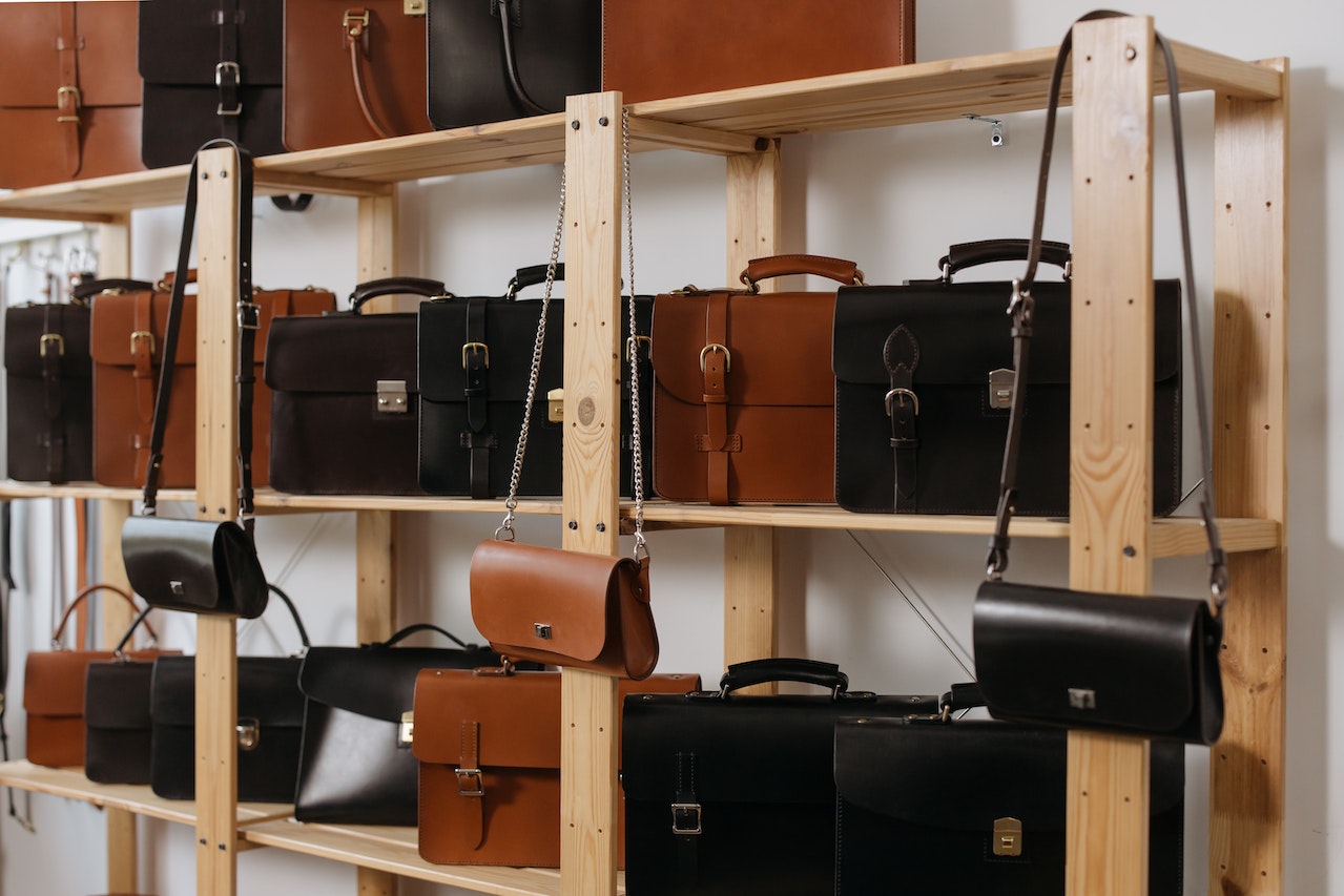 different leather bags on wooden shelves