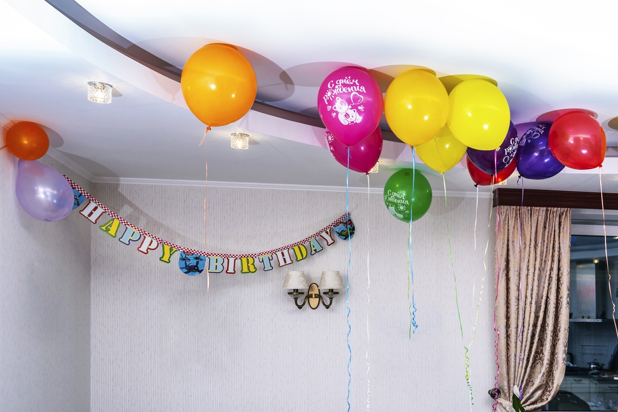 balloons of different colors stuck on the ceiling
