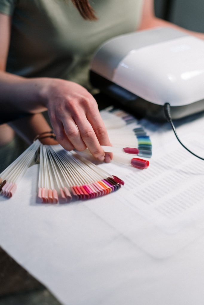 person-holding-artificial-nail-samples