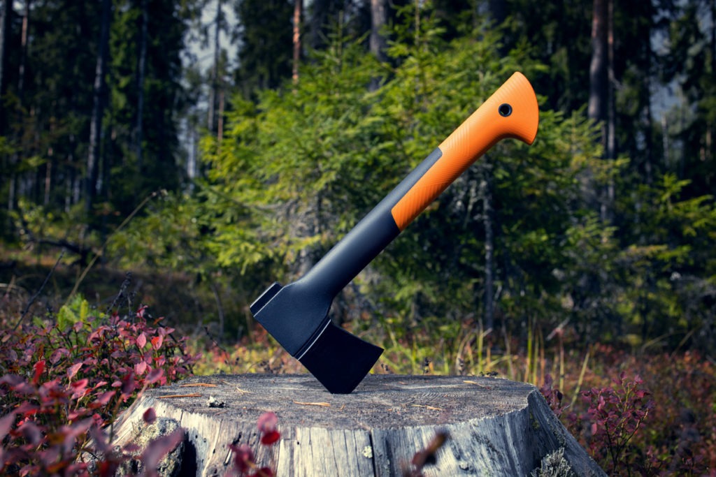 An axe stuck in an old stump in the forest