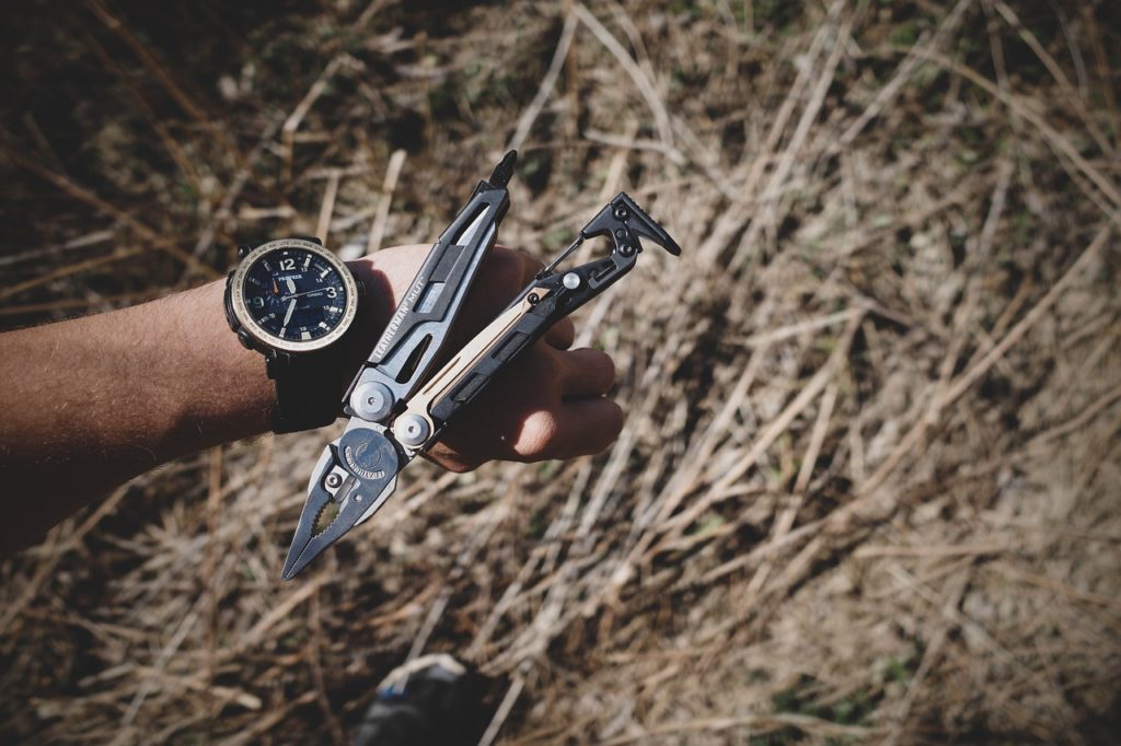 man with pocket size multi tool containing a plier and knife