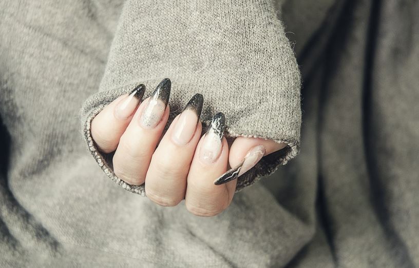 a closed palm of a woman with acrylic nails