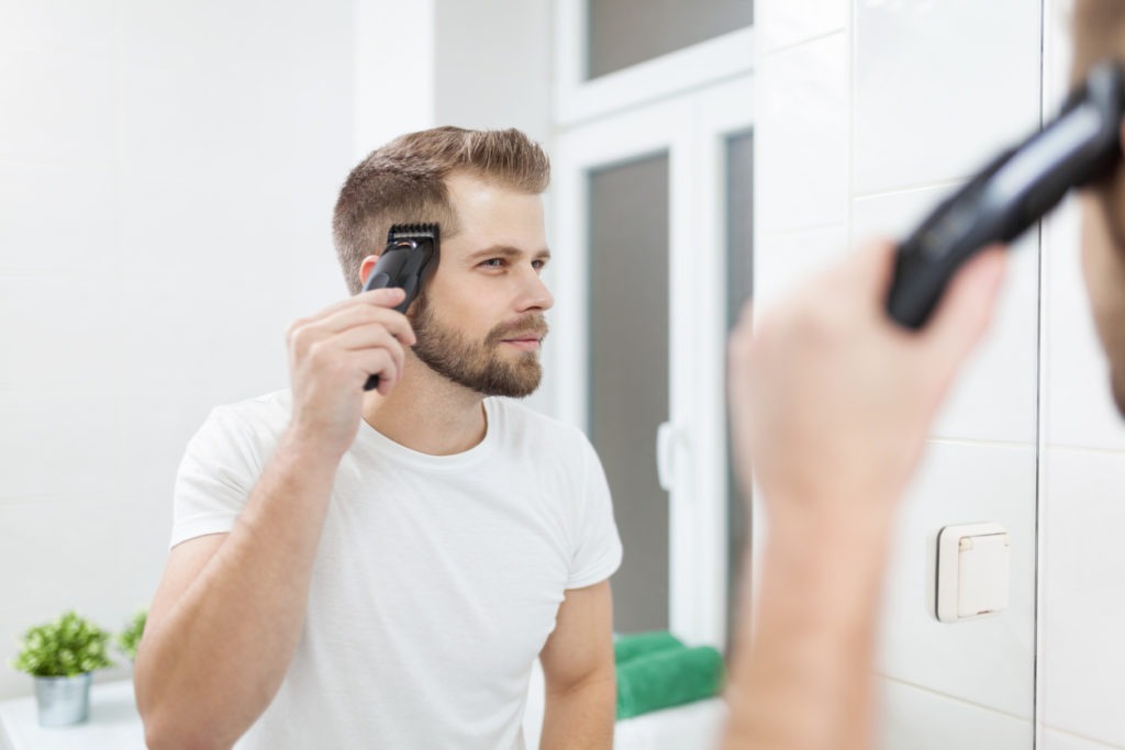 Man cutting his hair using clippers.