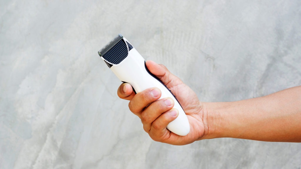 man holding a cordless hair clipper. 
