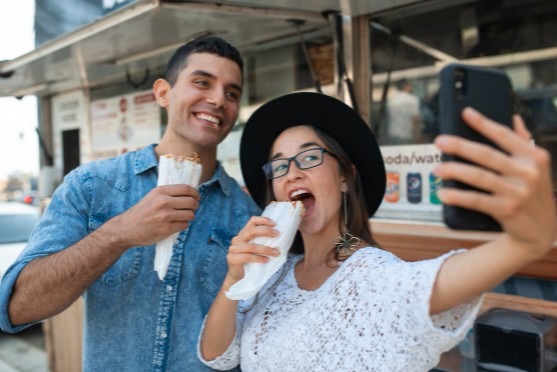 a couple having a selfie while eating shawarma