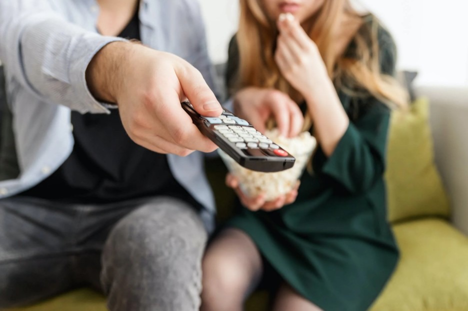a hand holding TV remote control