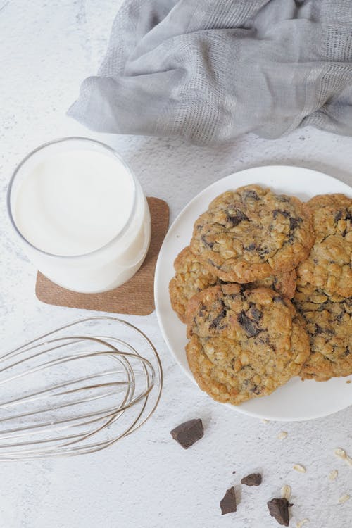 a plate of chocolate chip cookies and a glass of milk