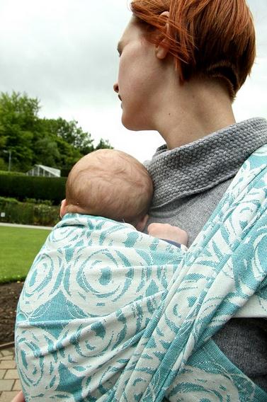A mom wearing her baby on a baby carrier