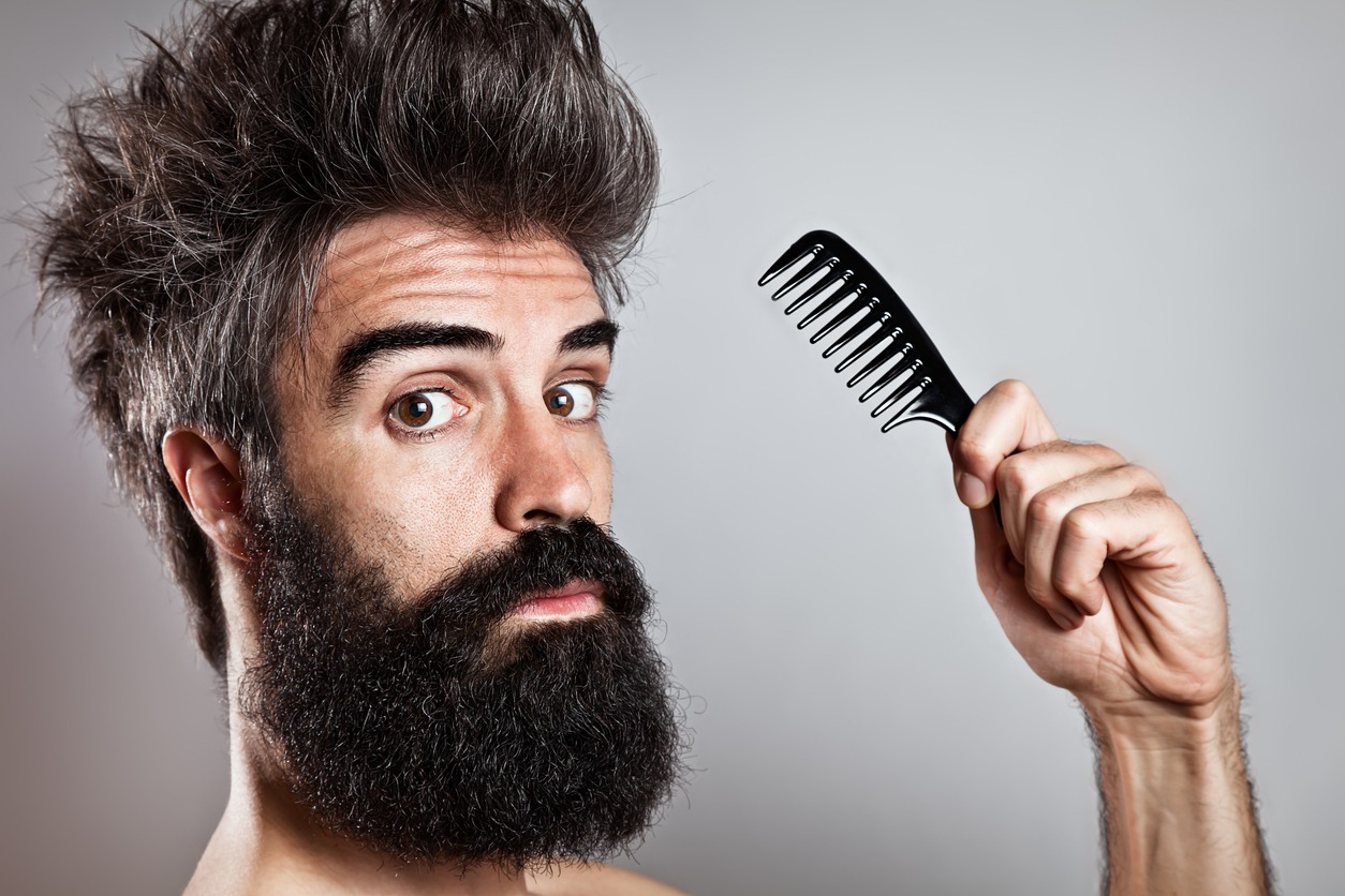 A man using a beard comb