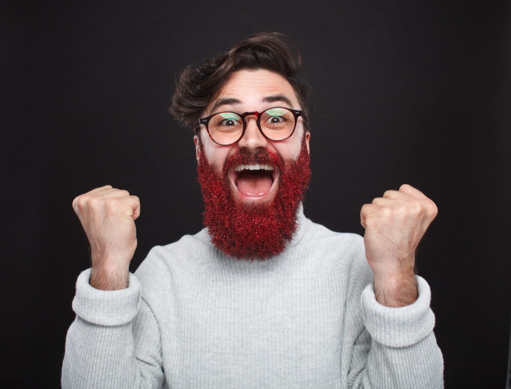Excited trendy man with glittering beard