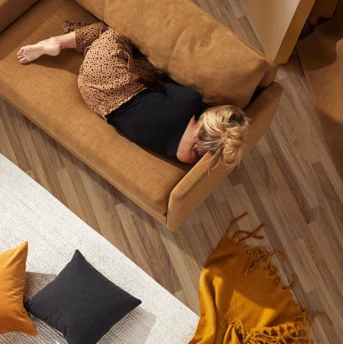 a woman resting on a brown couch