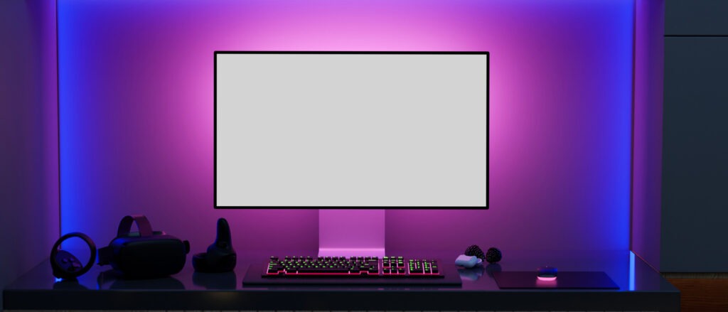 A computer desk setup with lights in the background
