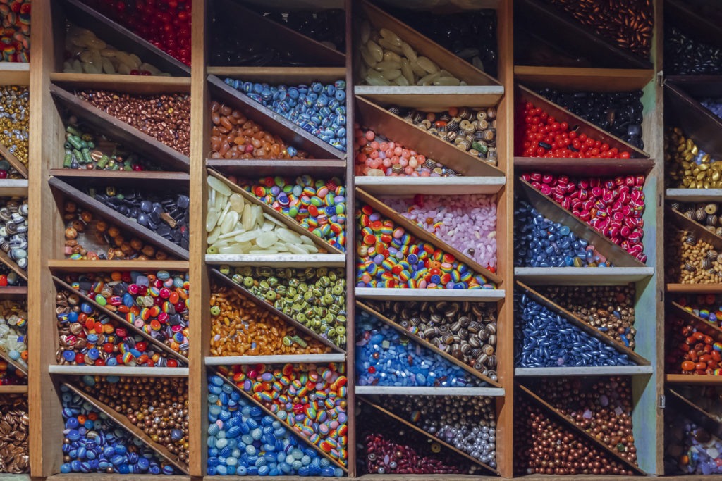 Flat lay of many colorful beads in wooden box