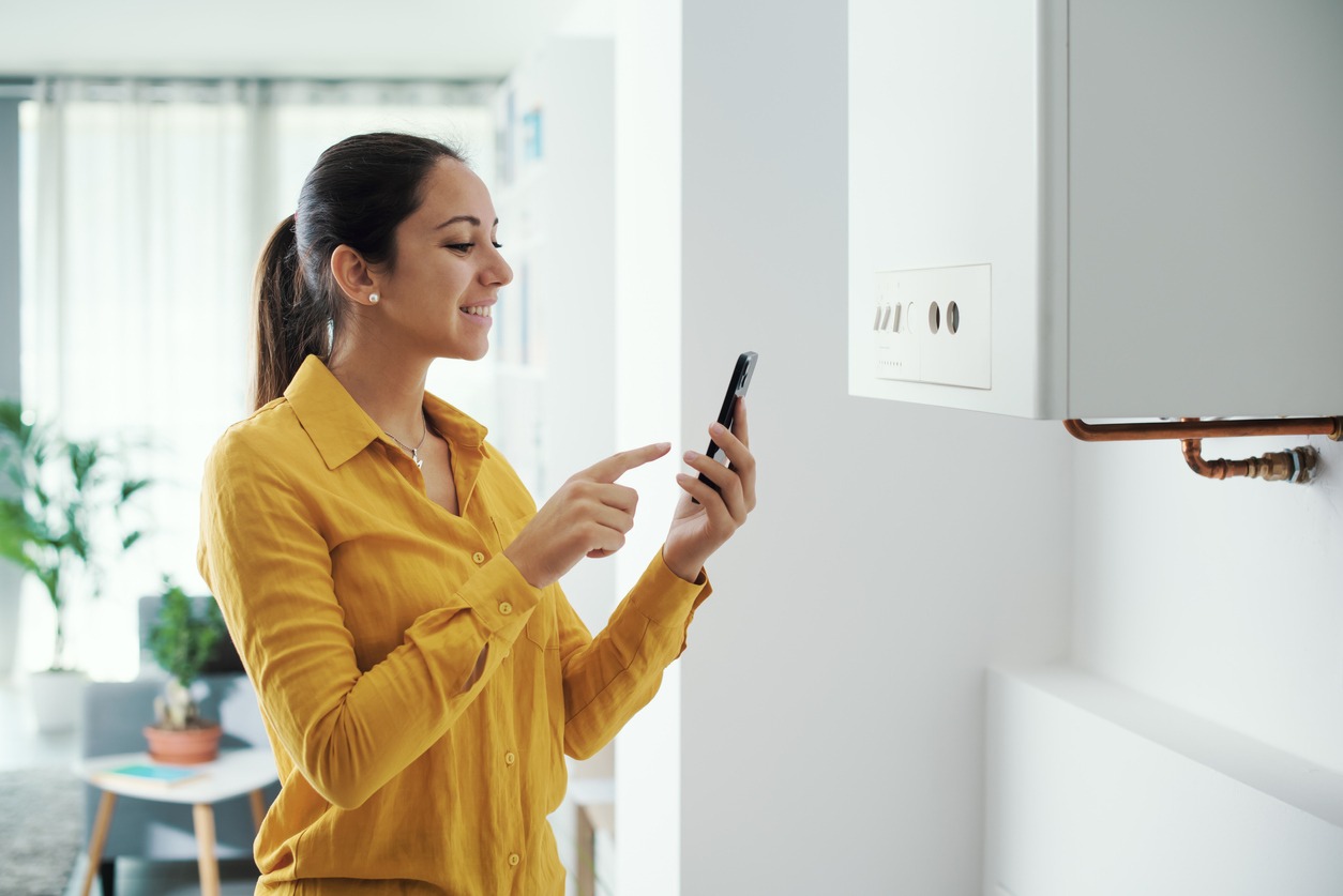 A Woman managing her smart boiler using her smartphone