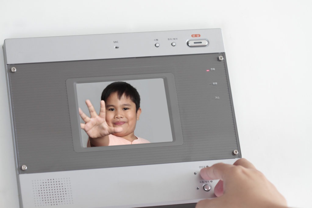  A video doorbell inside intercom showing a child on its screen being recorded from outside