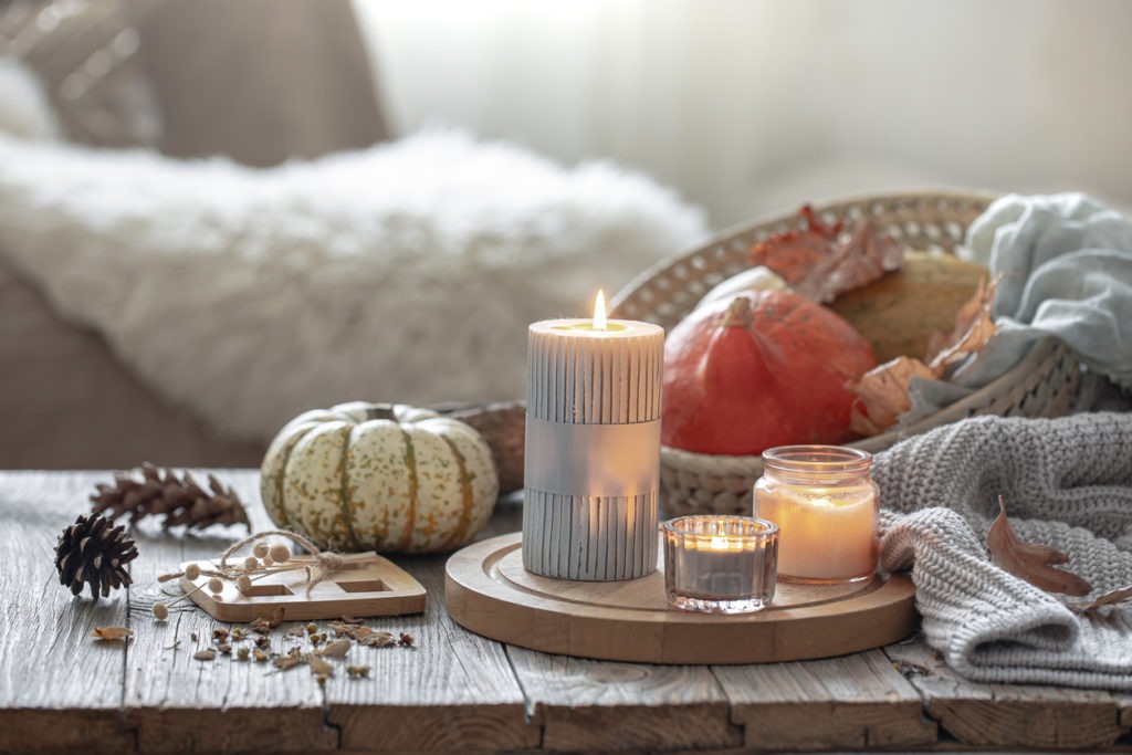 Cozy autumn composition with candles and pumpkins in a home interior