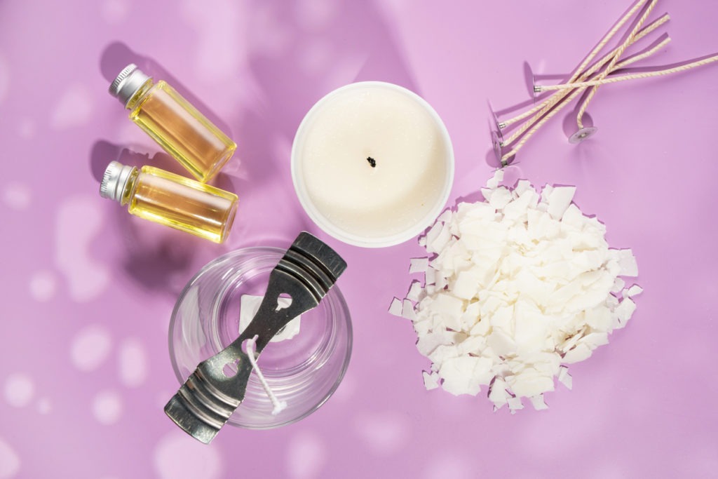 Set for homemade natural eco-friendly soy wax candles, wick, perfume, aroma oil. Candle making utensils.Trendy diy candles to health on pink background.Copy space.Cruelty-free vegan product