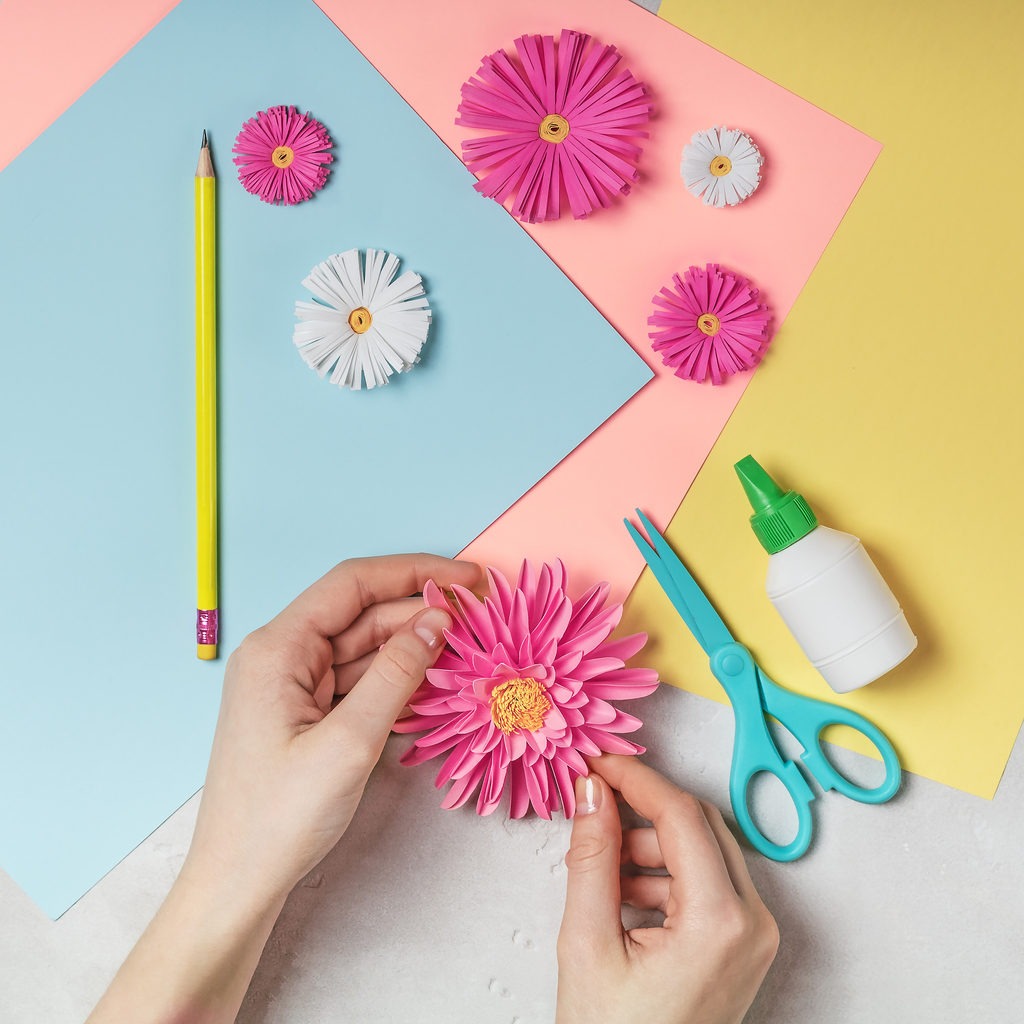Cutting out flower petals while crafting decorative paper flowers