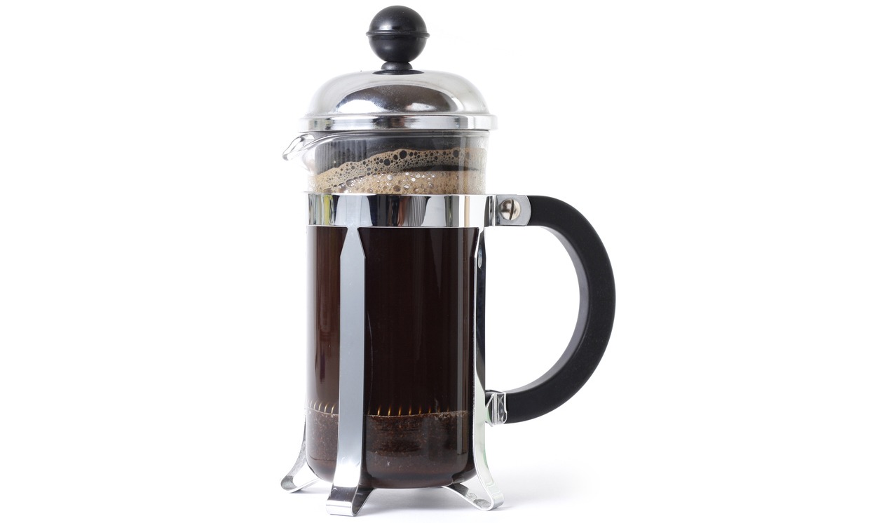 French press with coffee in white background