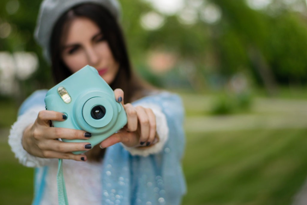 Woman taking a picture with an instant camera