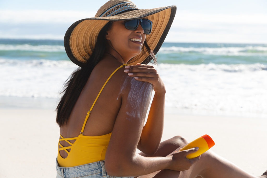  Woman using a sunscreen on the beach