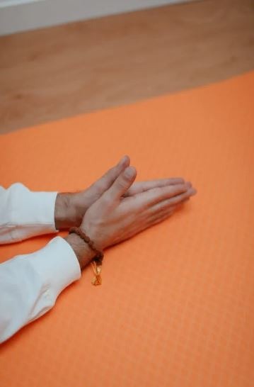 a person’s wearing a sandalwood bracelet with his hands in a prayer form