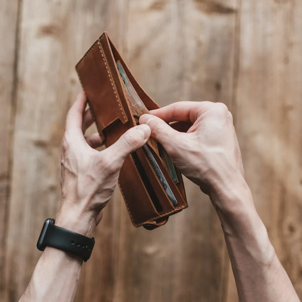 a picture of a man holding a brown leather wallet