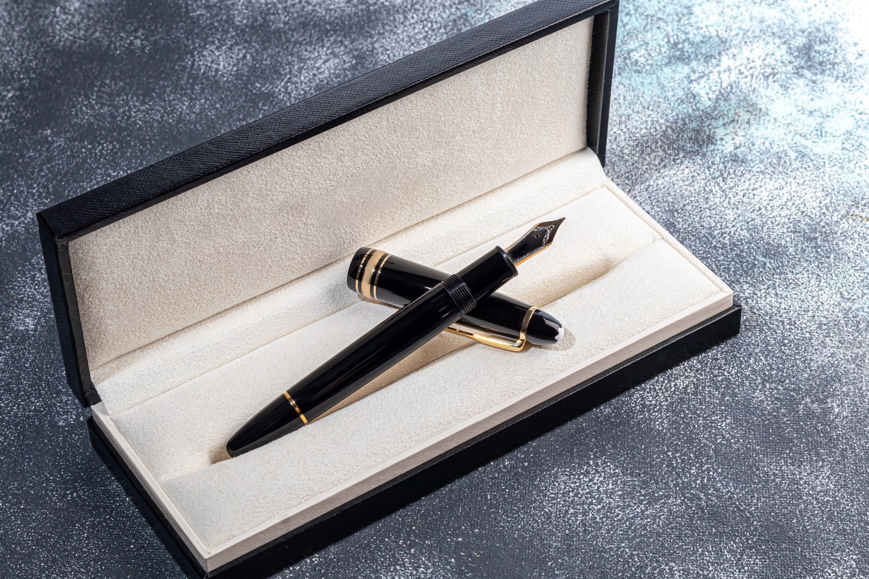 black fountain pen with a box on a marble and gray background