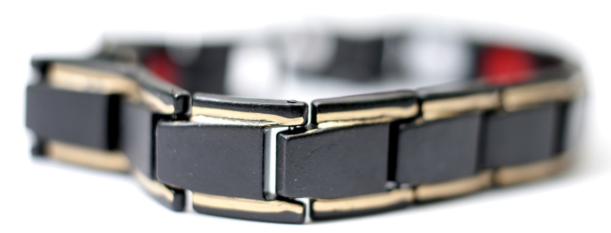 gold and black tone bracelet in white background