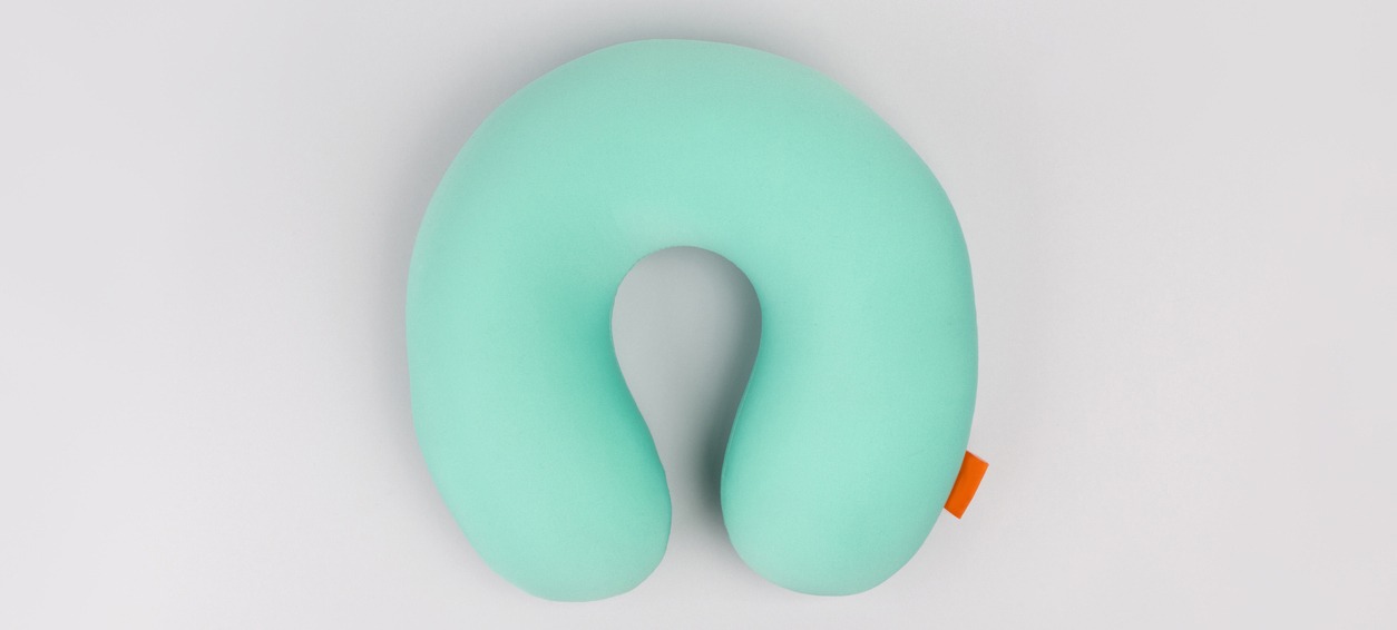 green neck pillow in grey background