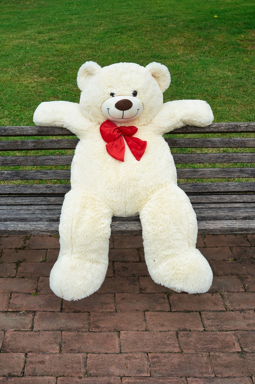 large polar bear stuffed toy sitting in a bench
