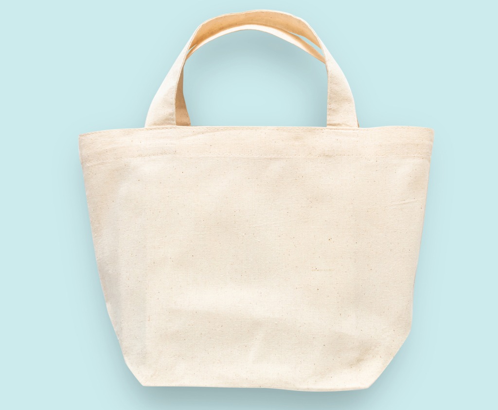 peach canvas tote bag in pastel blue background